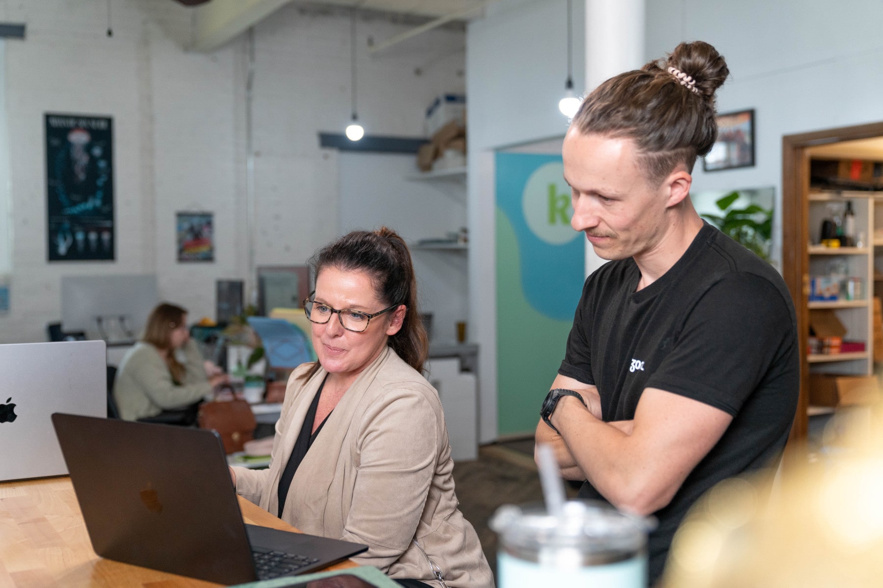 A designer meets with a client during a website relaunch meeting.