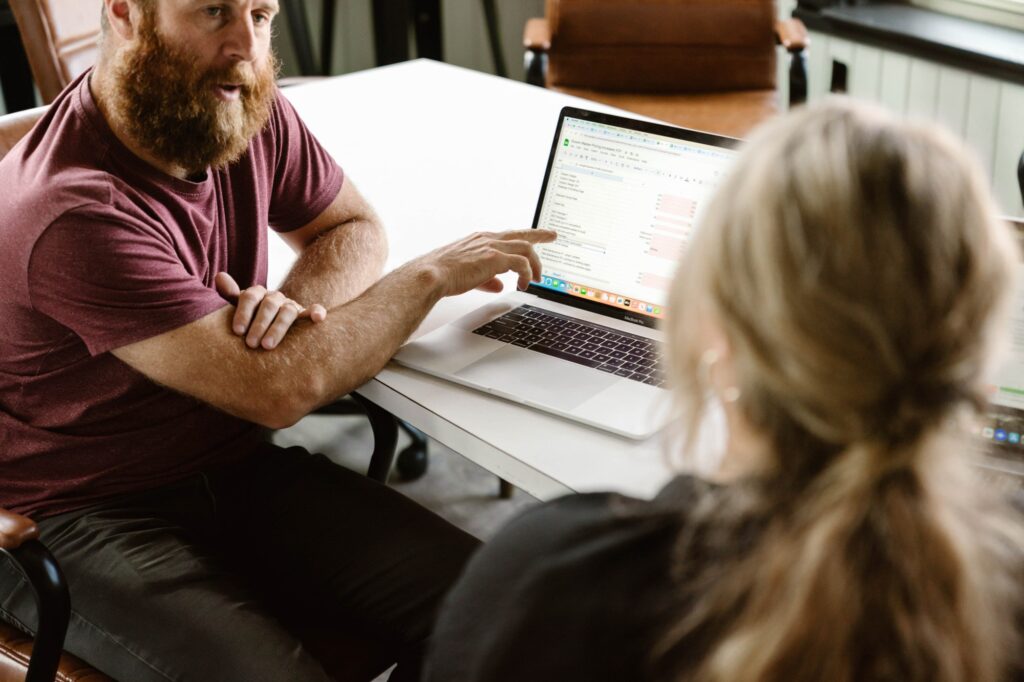 Dan Martin of Kzoom explains local keyword research to a client at a table.